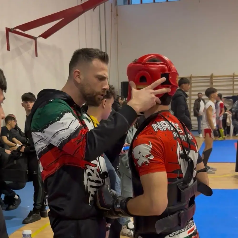 Antonio Russo sistema il casco a un atleta prima dell'incontro